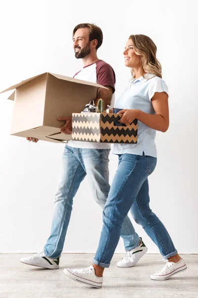 Photo de couple heureux tenant des boîtes en carton tout en marchant — Photo