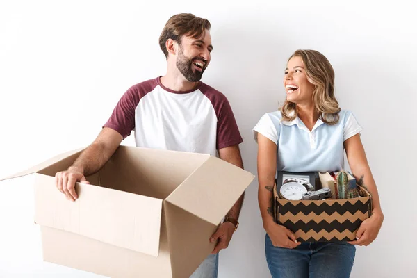 Foto de pareja riendo sosteniendo cajas mientras se miran entre sí —  Fotos de Stock