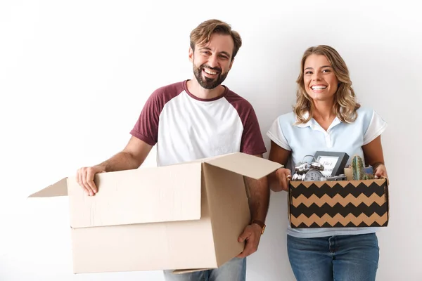 Foto de pareja riendo sosteniendo cajas mientras mira la cámara —  Fotos de Stock
