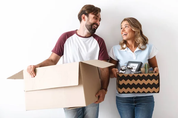 Foto de pareja divertida sosteniendo cajas mientras se miran entre sí — Foto de Stock