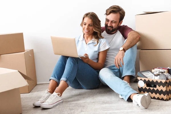 Foto de pareja feliz utilizando el ordenador portátil y abrazos mientras está sentado —  Fotos de Stock