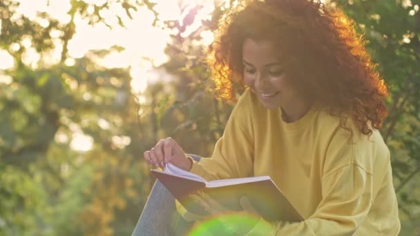 Jovem Mulher Positiva Com Cabelo Ruivo Encaracolado Lendo Livro Bebendo — Vídeo de Stock