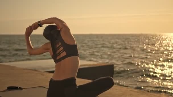 Sahilde Siyah Eşofman Giyen Sırtını Esneten Yoga Egzersizi Yapan Genç — Stok video