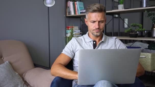 Aantrekkelijke Gefocuste Man Casual Kleding Met Behulp Van Zijn Laptop — Stockvideo