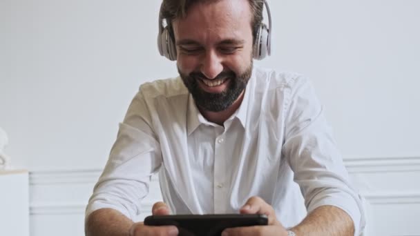 Vidám Jóképű Szakállas Üzletember Zenét Hallgat Okostelefonon Játszik Miközben Asztalnál — Stock videók