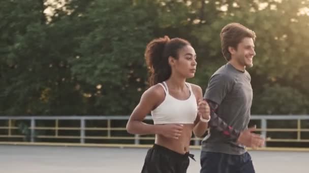 Motiviertes Läuferpaar Mann Und Frau Sportbekleidung Laufen Gemeinsam Auf Spielplatz — Stockvideo