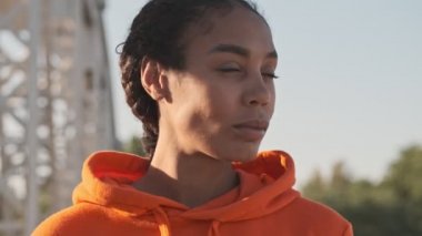 Odaklanmış Afro-Amerikan atletik kadın spor giyim sektöründe başını kameraya çeviriyor.