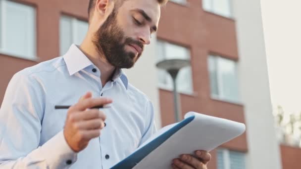 Close View Concentrated Smiling Bearded Businessman Holding Clipboard Writing Something — Stock Video
