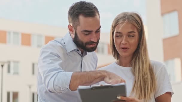 Felices Jóvenes Colegas Oficina Revisando Algo Portapapeles Discutiendo Mientras Están — Vídeo de stock