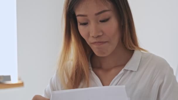 Positieve Aziatische Zakenvrouw Browsen Documenten Tijdens Het Werken Het Kantoor — Stockvideo