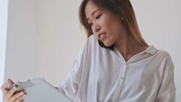 Koncentrerad Asiatisk Affärskvinna Tittar Mapp Tablett Med Dokument Samtidigt Ett — Stockvideo