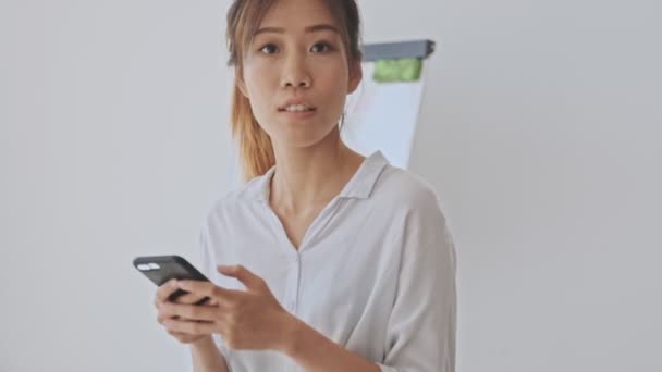 Bastante Asiático Mujer Haciendo Hola Gesto Mientras Agitando Mano Blanco — Vídeo de stock