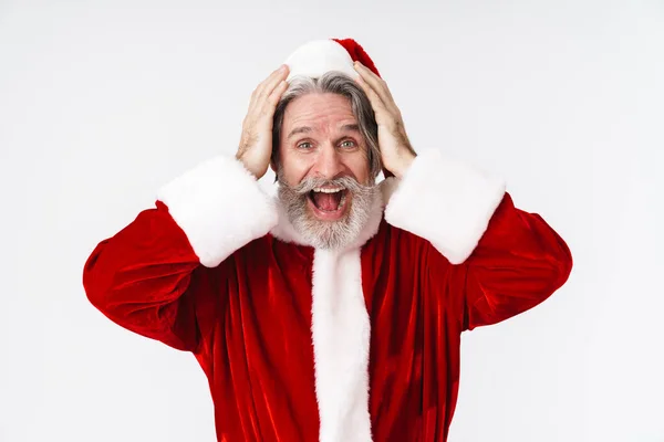 Bild eines glücklichen alten Weihnachtsmannes in rotem Kostüm, der nach seiner Hose greift — Stockfoto