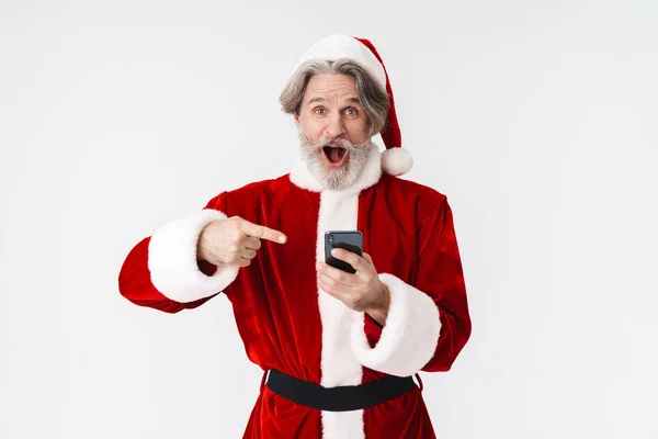 Bild des grauhaarigen Weihnachtsmannes im roten Kostüm mit Zelle — Stockfoto