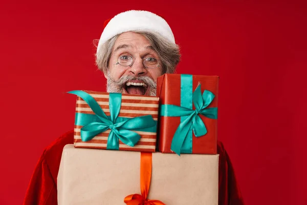 Bild eines Weihnachtsmannes mit Brille, der lacht und Geschenke in der Hand hält — Stockfoto