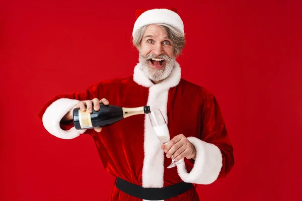 Bild eines glücklichen alten Weihnachtsmannes, der lächelt und Champagner in der Hand hält — Stockfoto