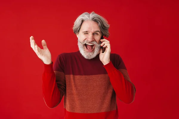 Retrato de homem velho barbudo de cabelos grisalhos em suéter falando sobre sm — Fotografia de Stock