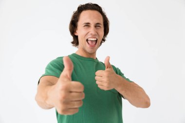 Çekici bir genç adamın gülüşü ve baş parmağını kaldırışı.