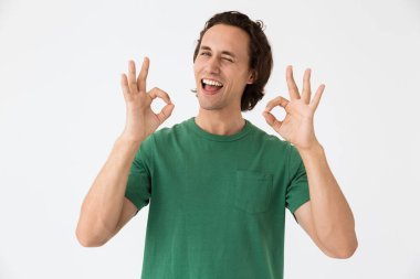 Gülen ve işaret gösteren neşeli genç bir adam.