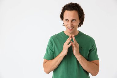 Basit tişörtler giyen çılgın bir adam komplo kurarken el kol hareketi yapıyor.