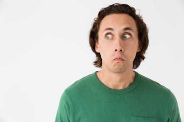 Şok olmuş genç bir adam şaşkınlıkla yan yana bakıyor.