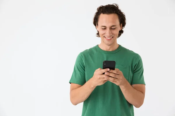 Beeld van aantrekkelijke brunette man glimlachen en het houden van smartphone — Stockfoto