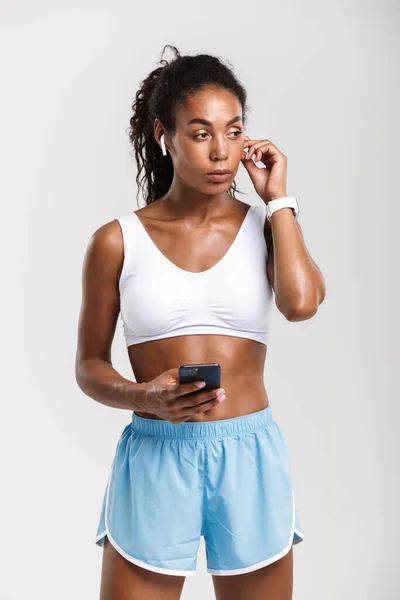 Retrato de mulher afro-americana usando celular e fones de ouvido — Fotografia de Stock