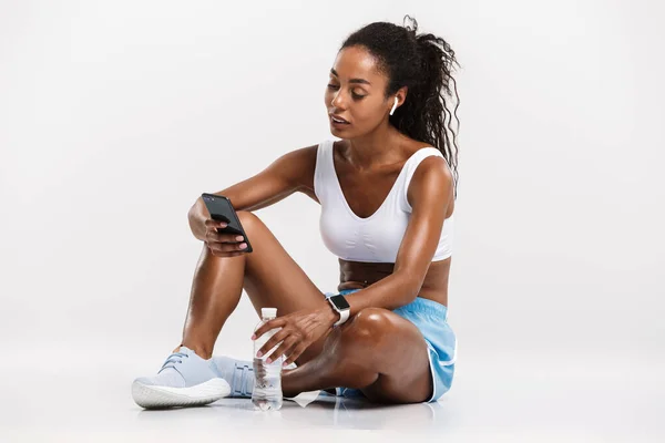 Porträt einer netten afrikanisch-amerikanischen Frau mit Handy und Ohrstöpseln — Stockfoto