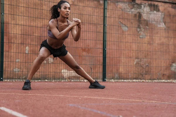 Photo of african american woman doing exercise while working out — Stock Photo, Image