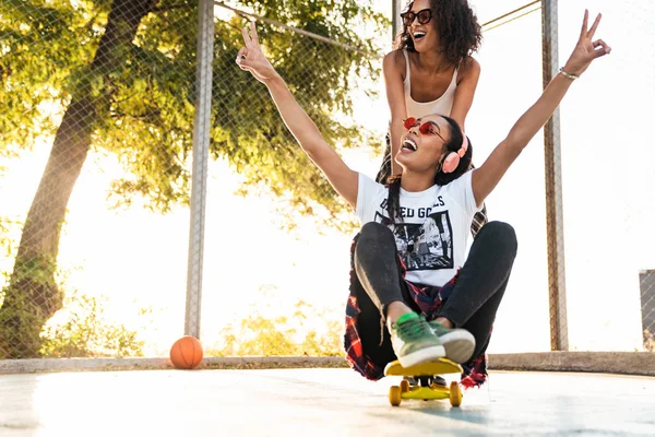 Image of american girls having fun and riding skateboard on play — Stock Photo, Image