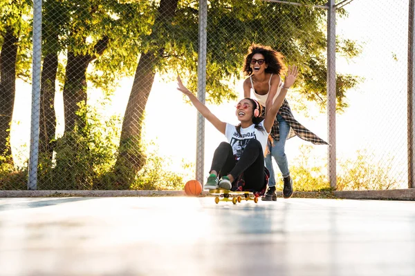 Afbeelding van amerikaanse meisjes hebben plezier en paardrijden skateboard op spel — Stockfoto