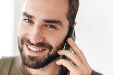 Kafkasyalı mutlu adamın cep telefonuyla konuşan ve gülümseyen görüntüsü.