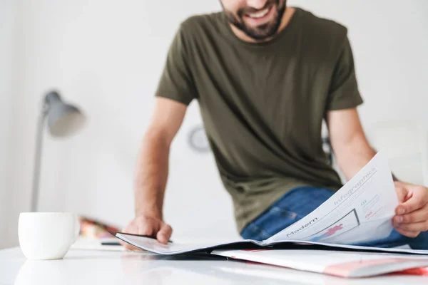 Cropped image of young smiling caucasian man reading documents — Stock Photo, Image