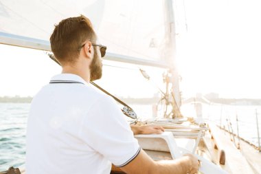 Denizdeki yatta yakışıklı, harika bir genç adam..