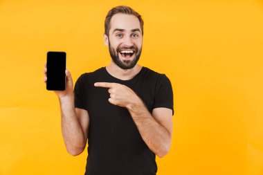 Çekici bir adamın gülümsemesi ve cep telefonunu işaret etmesi.