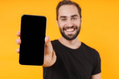 Pozitif adamın gülümsemesi ve cep telefonunu kameraya göstermesi