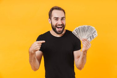 Tişört giyen, gülümseyen ve para tutan başarılı bir adamın görüntüsü