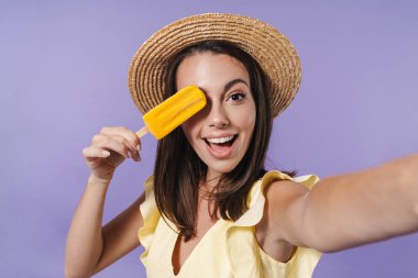 Yazlık elbise ve hasır şapka giyen neşeli güzel kız.