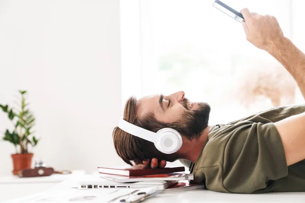 Kép a férfi zenét hallgat fejhallgatóval és a mobiltelefon — Stock Fotó