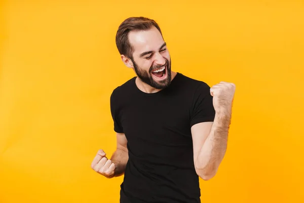 A boldog férfi képe pólóban mosolyog és ünnepli a győzelmet — Stock Fotó