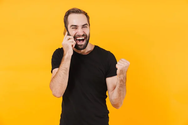 Bild eines fröhlichen Mannes im T-Shirt, der jubelt und auf sma spricht — Stockfoto