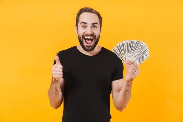 Bild av lycklig man klädd i t-shirt leende och hålla pengar cas — Stockfoto