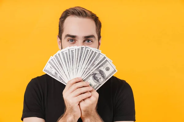 Image of young man wearing basic black t-shirt holding money cas — 스톡 사진