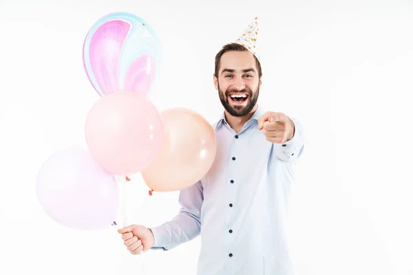 Image of pleased party man holding air balloons and pointing fin — Stock Photo, Image