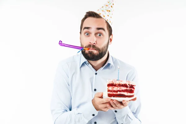 Image of positive man blowing party horn and holding birthday ca — Stock Photo, Image