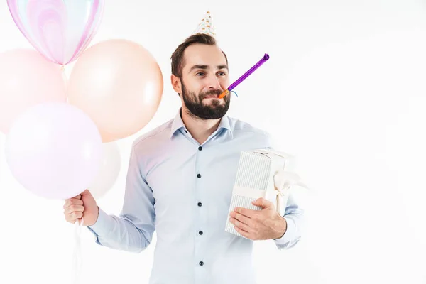 Image of man blowing party horn while holding air balloons and p — Stock Photo, Image