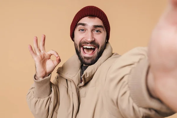Εικόνα του θετικού νεαρού άνδρα gesturing ok σημάδι, ενώ λαμβάνοντας selfi — Φωτογραφία Αρχείου