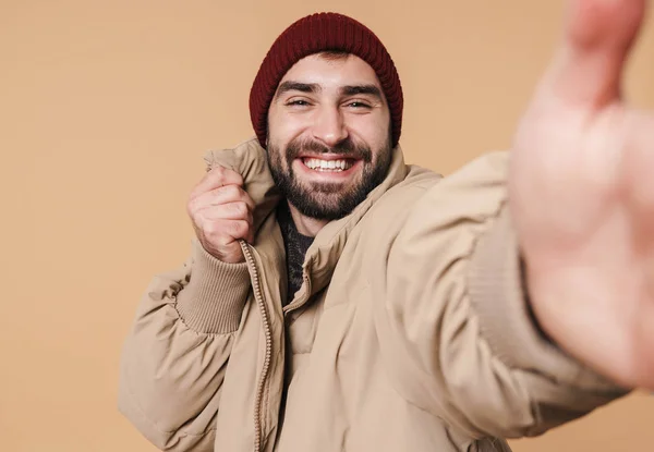 Bild eines Mannes in Winterjacke und Hut, der beim Selfi lächelt — Stockfoto