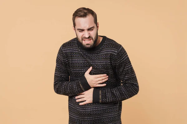 Bild eines jungen unrasierten Mannes, der vor Schmerzen seinen Bauch berührt — Stockfoto