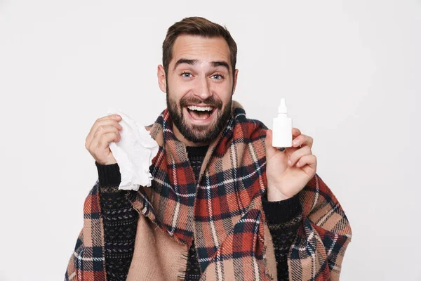 Retrato de tipo enfermo envuelto en manta estornudando y sosteniendo la nariz — Foto de Stock